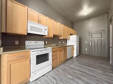 Des Moines apartment for rent - A kitchen with wooden cabinets and white appliances.