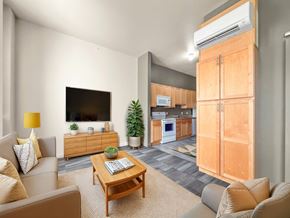 Des Moines apartment for rent - A living room with a brown couch, a wooden coffee table, and a television.