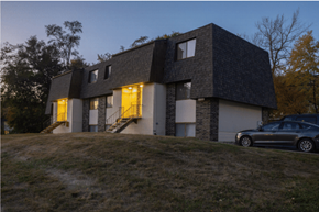 Des Moines townhouse for rent - A modern house with a dark grey roof and a car parked in front.