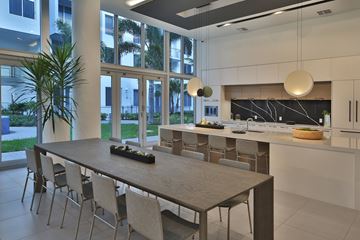 Dania Beach apartment for rent - A modern kitchen with a dining table and chairs.