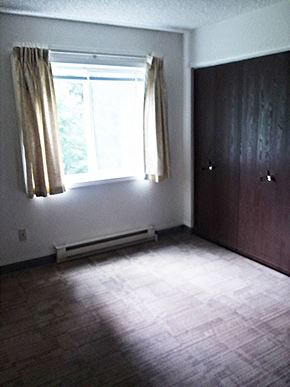 Superior apartment for rent - Image of bedroom with closet, base board heater, and window