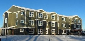 Great Falls apartment for rent - A large building with a lot of windows and a snowy ground.