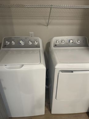 Hamilton apartment for rent - Two white front loading washing machines in a laundry room.