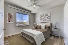 Helena apartment for rent - A bedroom with a large bed, a ceiling fan, and a window with a view of the sky.