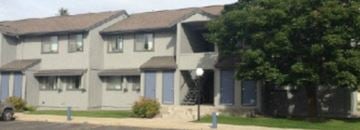 Kalispell apartment for rent - a white house with blue shutters and a street with trees