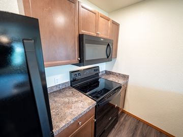 Casper apartment for rent - a kitchen with a stove and microwave and wooden cabinets