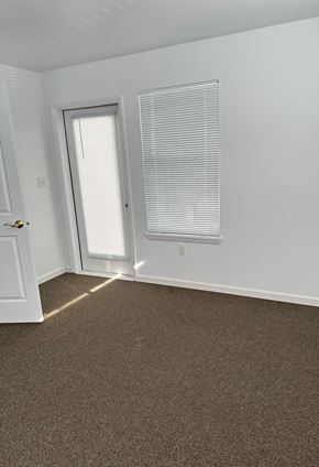 Evanston apartment for rent - A room with a brown carpet and a white door.
