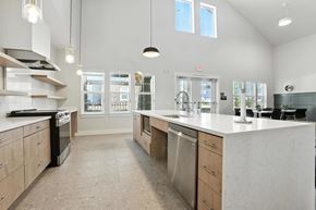 Caldwell apartment for rent - A modern community room with kitchen with a large island and stainless steel appliances.
