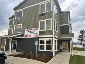 Hamilton apartment for rent - A two-story building with a sign that says "NOW LEASING" and a website address.