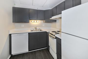 Southfield apartment for rent - A kitchen with black cabinets and white appliances.