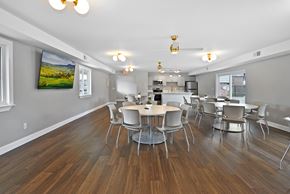 Warren apartment for rent - Resident clubhouse with comfortable seating, community tables, and bright natural light at Warren Woods Apartments in Warren, MI.