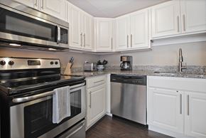 Saginaw apartment for rent - Kitchen with Granite countertops, Stainless Steel Appliances, Dishwasher, cabinet space, and hardwood floors at Bancroft Apartments in Saginaw, MI