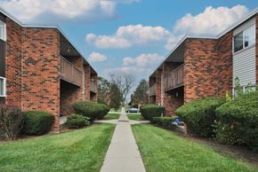 Flint apartment for rent - A long, narrow walkway separates two rows of red brick apartment buildings.