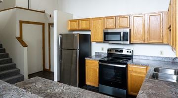 Grand Rapids apartment for rent - a kitchen with stainless steel appliances and wooden cabinets