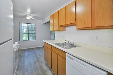 Clinton Twp apartment for rent - A kitchen with wooden cabinets and a white dishwasher.