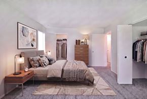 Clinton Twp apartment for rent - A bedroom with a bed, nightstand, and a painting on the wall.