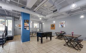 Grand Rapids apartment for rent - a room with a foosball table and tables with chairs at The Lofts at 5 Lyon, in downtown Grand Rapids, MI