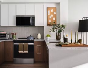 Jersey City apartment for rent - A modern kitchen with a black oven and wooden cabinets.