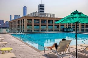 Jersey City apartment for rent - A woman is sunbathing by a pool on a sunny day.