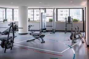 Jersey City apartment for rent - A gym with a variety of equipment including weights and a bench.