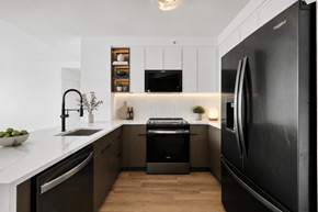 Jersey City apartment for rent - A modern kitchen with a black refrigerator and wooden floors.