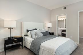 Overland Park apartment for rent - a bedroom with a bed and two nightstands and a bathroom with a mirror