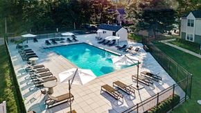 Philadelphia apartment for rent - A large outdoor swimming pool surrounded by sun loungers and umbrellas.
