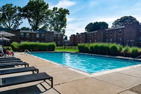 Philadelphia triplex for rent - a swimming pool in front of a brick apartment building at Rushwood Apartments, Pennsylvania, 19154