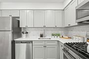 Philadelphia apartment for rent - A modern kitchen with a stainless steel refrigerator, a white countertop, and a black stove top.