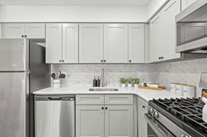 Philadelphia apartment for rent - A modern kitchen with a stainless steel refrigerator, a white countertop, and a black stove top.
