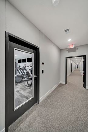 Lincoln apartment for rent - a hallway with a door to a gym with a mirror on the wall
