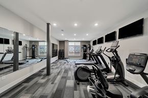 Lincoln apartment for rent - a gym with cardio machines and televisions on the wall
