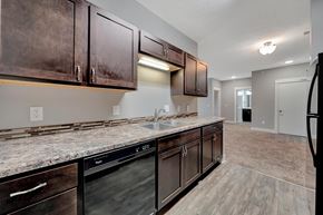 Lincoln apartment for rent - A kitchen with dark brown cabinets and a granite countertop.