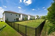 Antioch apartment for rent - A black fence surrounds a grassy area in front of a row of houses.