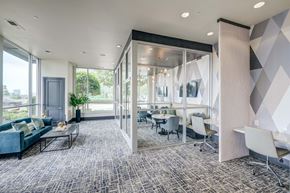 Dallas apartment for rent - a conference room with glass walls and tables and chairs