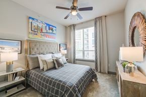 Dallas apartment for rent - a bedroom with a large bed and a ceiling fan