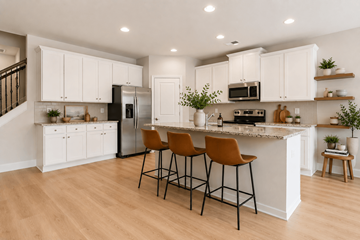 Snellville townhouse for rent - A kitchen with white cabinets and a black refrigerator.