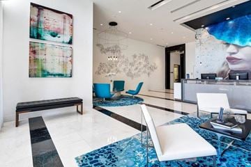Miami apartment for rent - a living room with a white couch and a table with chairs