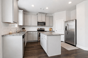 Loganville apartment for rent - Spacious kitchen with an island, ample storage, stainless steel appliances and view into the living room.