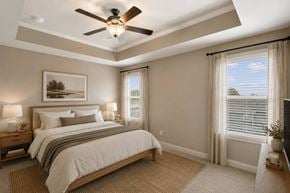 Dacula townhouse for rent - A bedroom with a large bed and a ceiling fan.