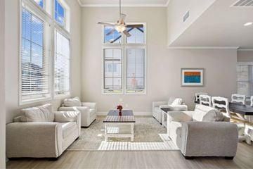 Dacula townhouse for rent - A living room with white furniture and a ceiling fan.