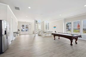Dacula townhouse for rent - A spacious kitchen with a pool table and a refrigerator.