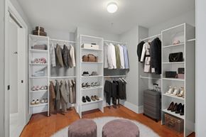 Jersey City apartment for rent - A spacious walk-in closet with organized shelves and clothes.