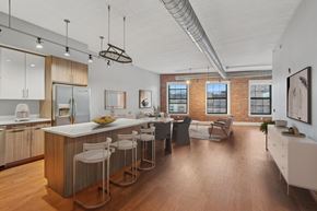 Jersey City apartment for rent - A kitchen with white chairs and a white table with a bowl of fruit on it.