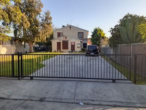 Los Angeles apartment for rent - A black gate blocks the driveway to a house.