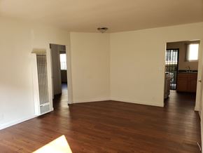 Los Angeles apartment for rent - A large empty room with wood flooring and white walls.