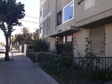 Los Angeles apartment for rent - the side of an apartment building with a sidewalk and a fence