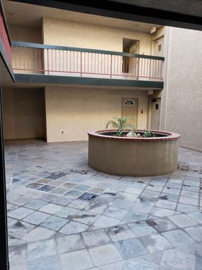San Pedro apartment for rent - an empty courtyard with a fountain in front of a building