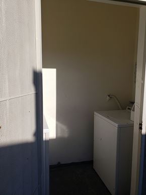 Los Angeles apartment for rent - A white washing machine sits in a small room.