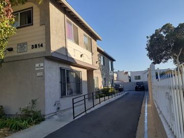 Los Angeles apartment for rent - A street view of a residential area with houses on both sides and a car parked on the street.